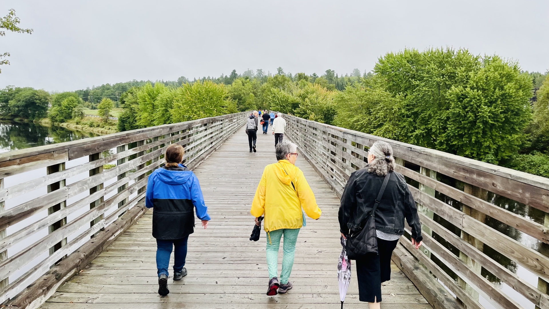 A group of people walking across a bridge.