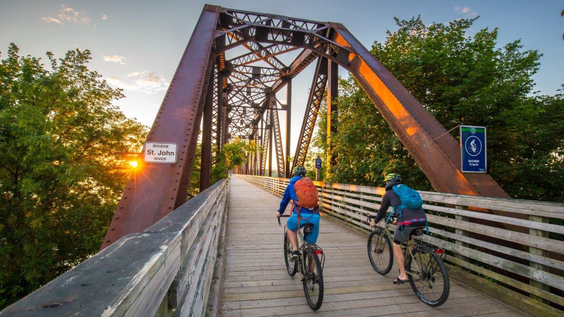 Two bikers on Bill Thrope Walking Bridge at sunset