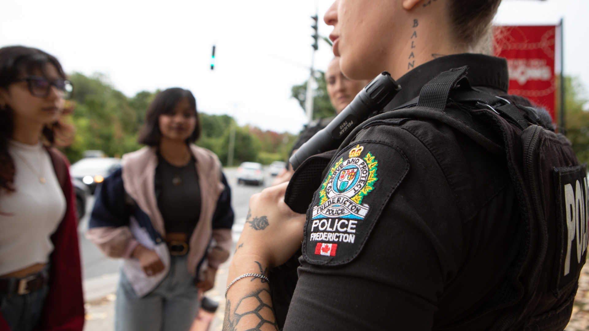 Fredericton Police Force Uniform talking with two women