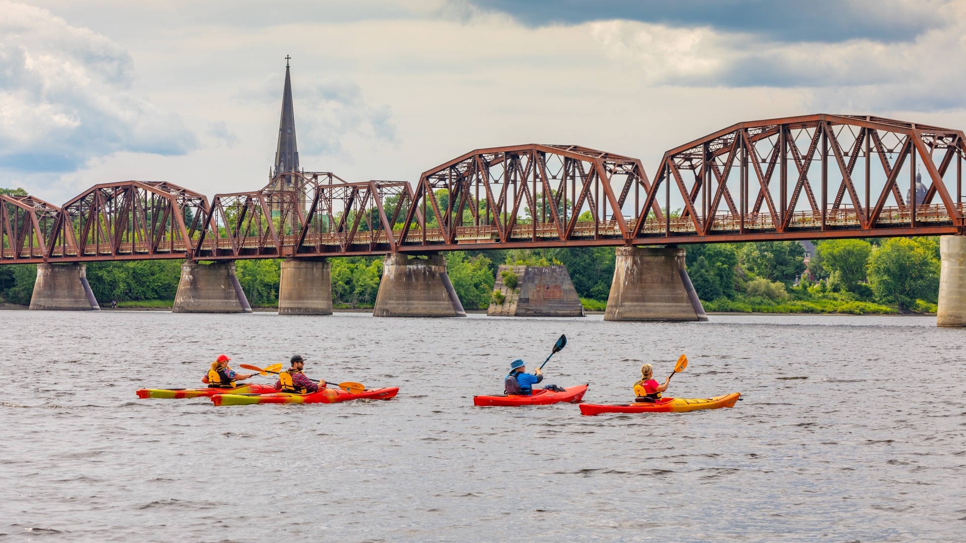 Kayaker on the river in front of the Bill Thorpe Walking Bridge