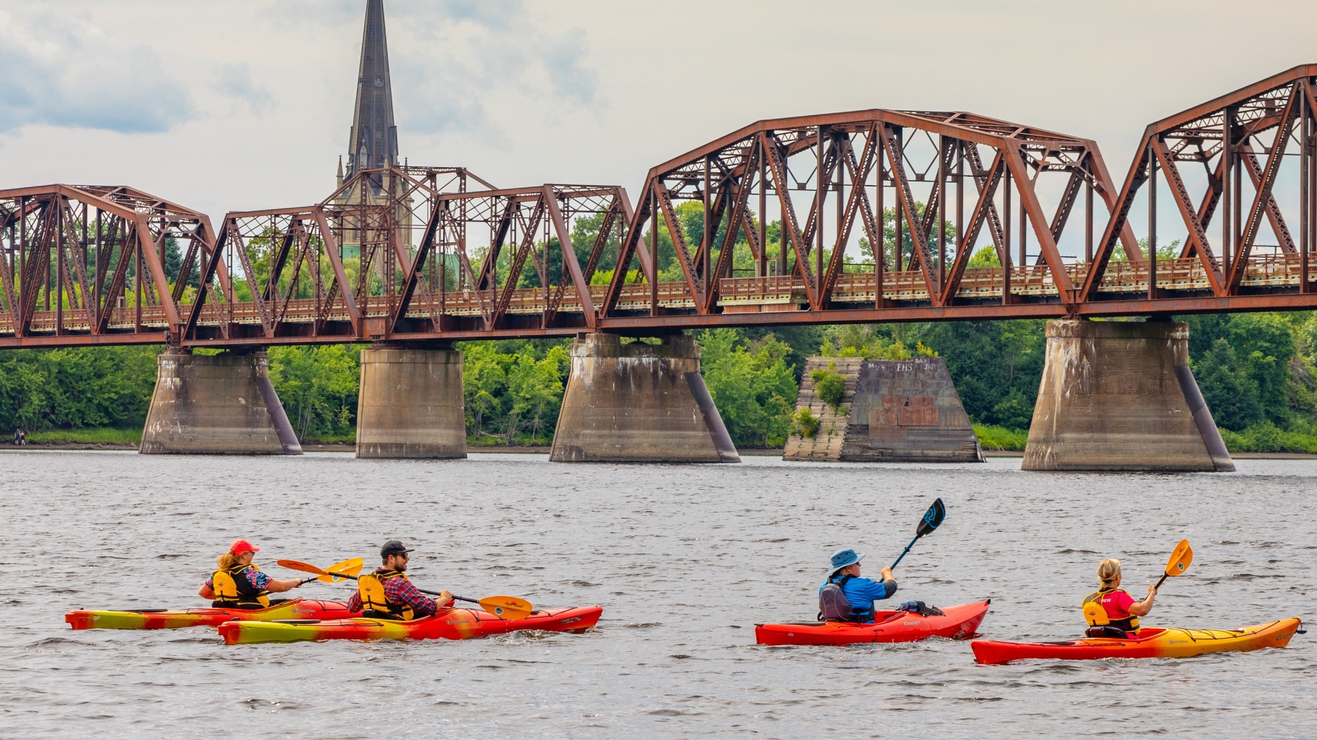 Kayaker on the river in front of the Bill Thorpe Walking Bridge