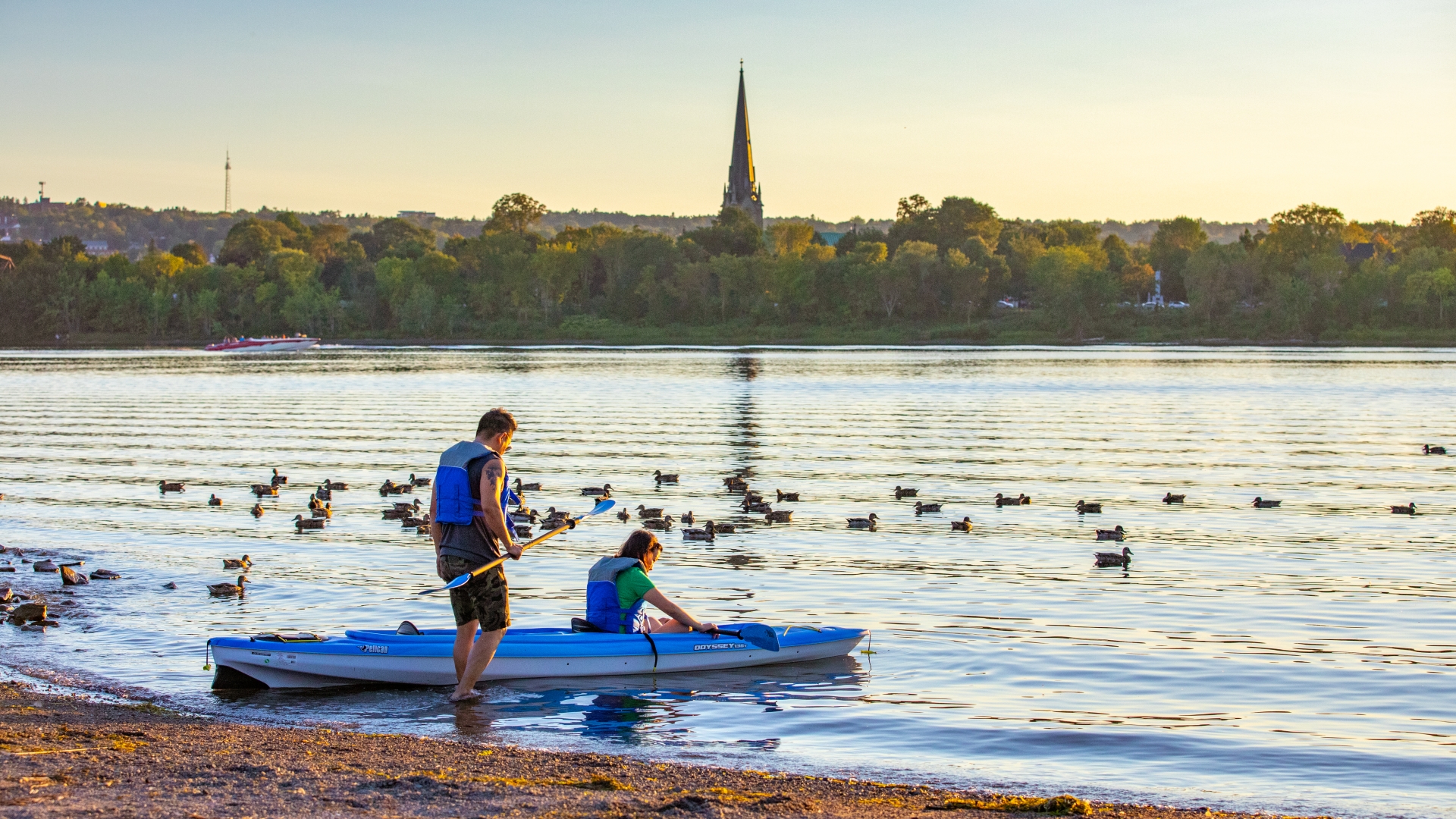 Man and women putting a kayak into the river