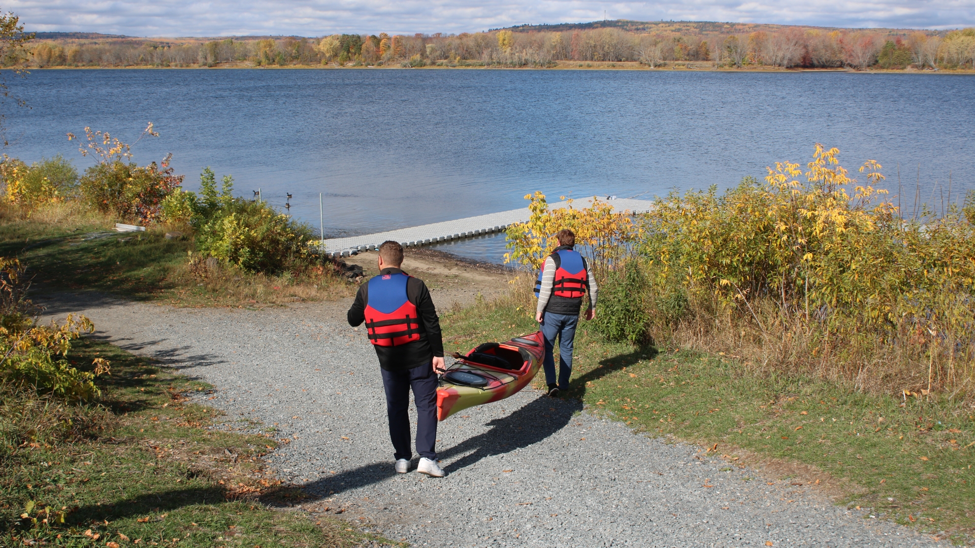 Two men carrying Kayak to river