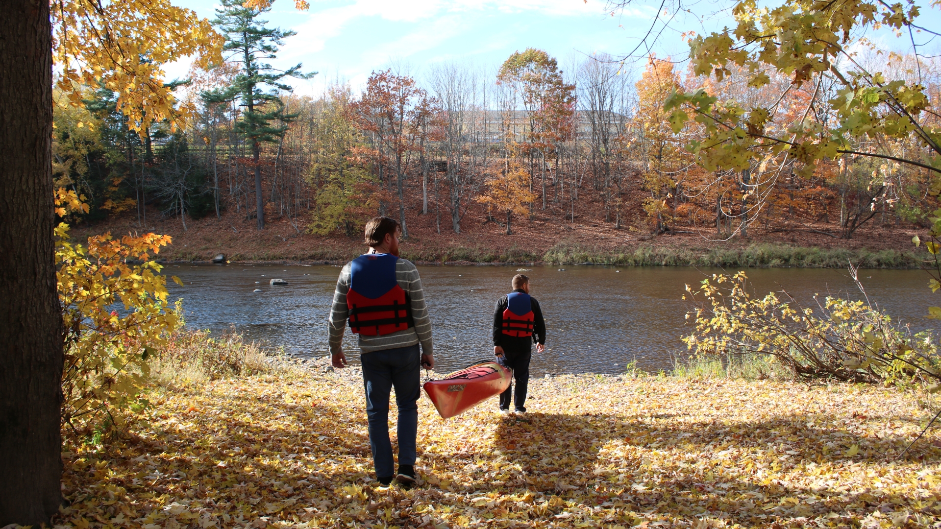Two men carrying Kayak to river
