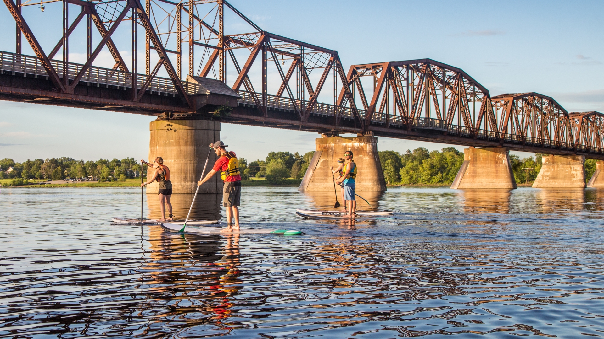 Paddleboarders on the river near the Bill Thorpe Walking Bridge