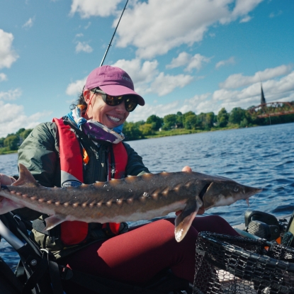 Women holding fish on the river
