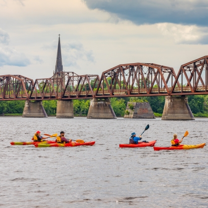 Kayaker on the river in front of the Bill Thorpe Walking Bridge