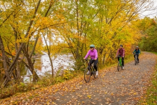 Three bikers on a trail next to river