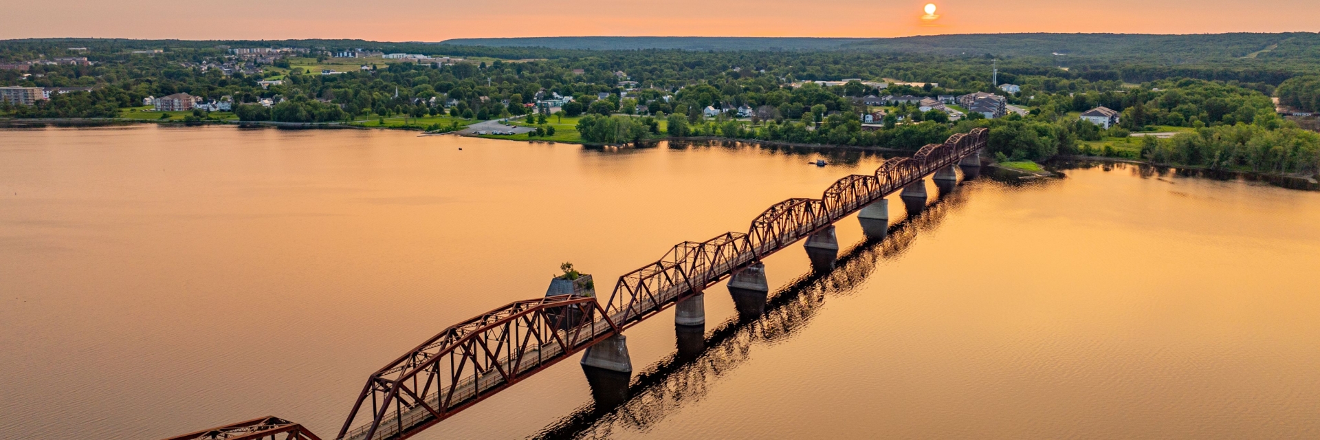 river sunset photo with bill thorpe walking bridge in the middle